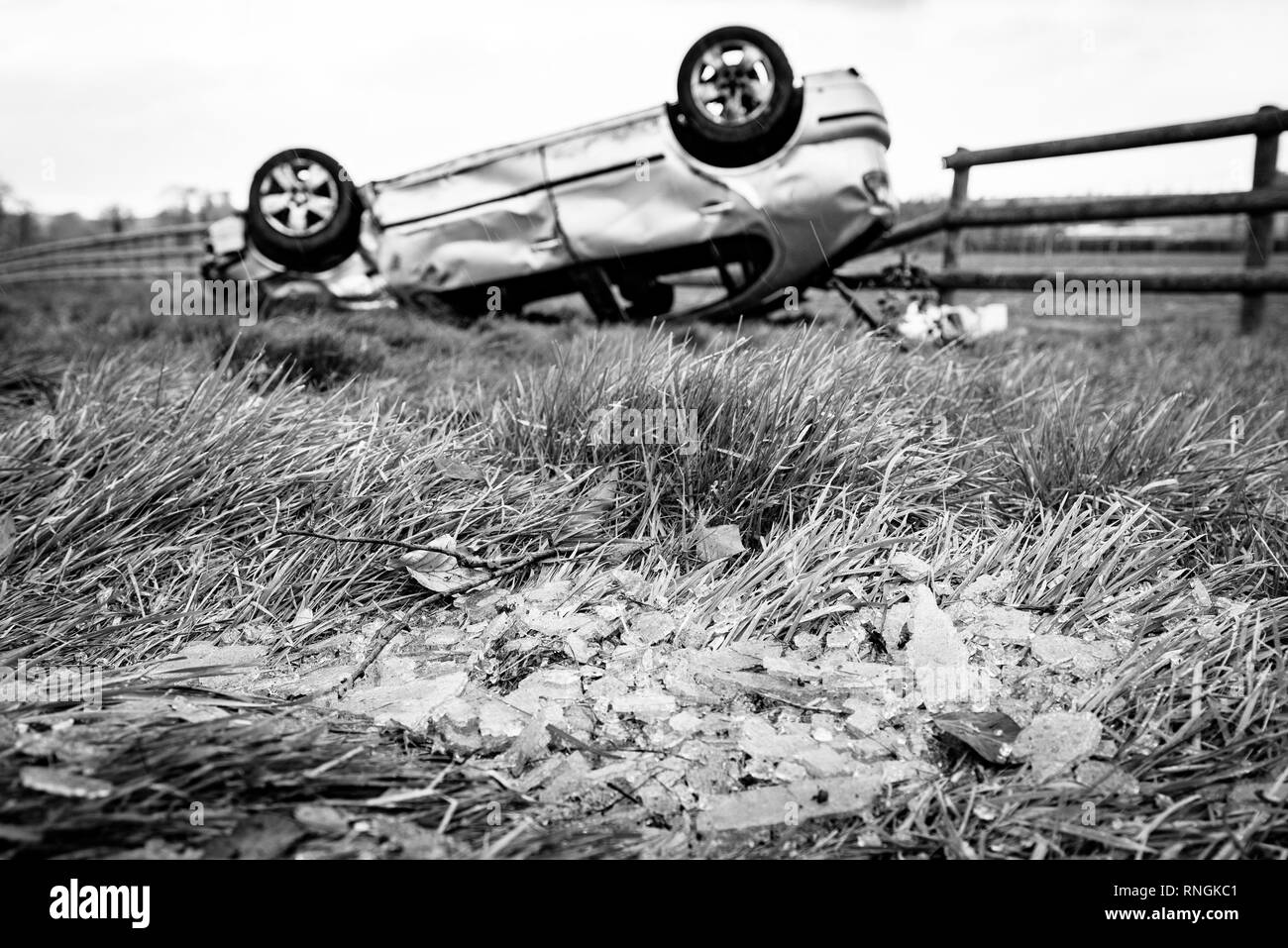 Auto Crash und Auto beschädigt werden. Fahrzeug kopfüber in einem Feld durch Glasscherben und Schmutz umgeben nach einem High-Speed-Crash. Stockfoto