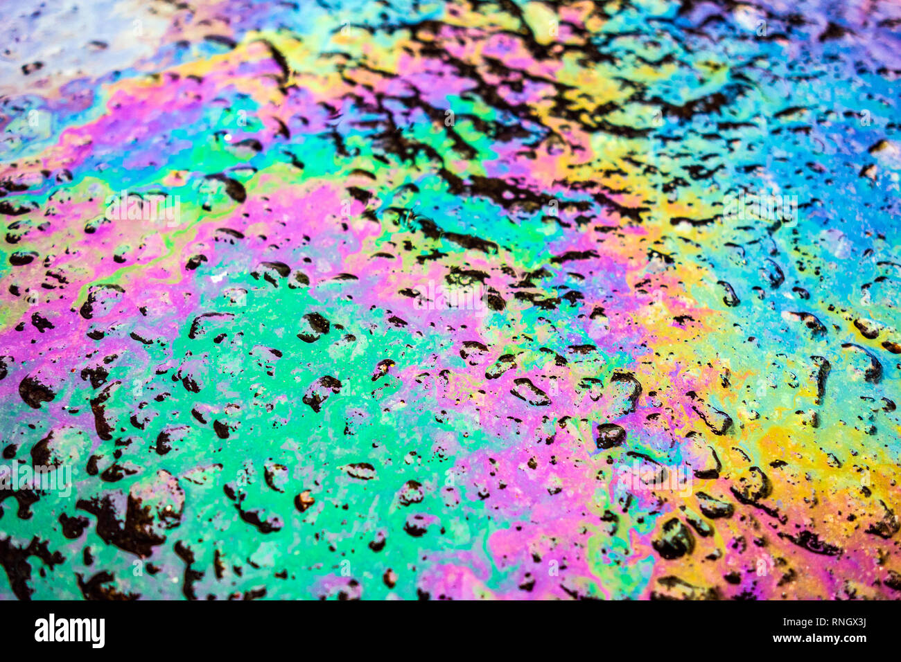 Benzin Benzin Ölpest Regenbogen auf Asphaltstraße Stockfoto