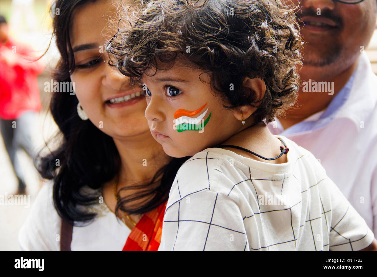 PUNE, MAHARASHTRA, Indien, 15. August 2018, kleines Baby mit Indischen dreifarbig auf Wange mit seiner Mutter feiern Tag der Unabhängigkeit lackiert Stockfoto