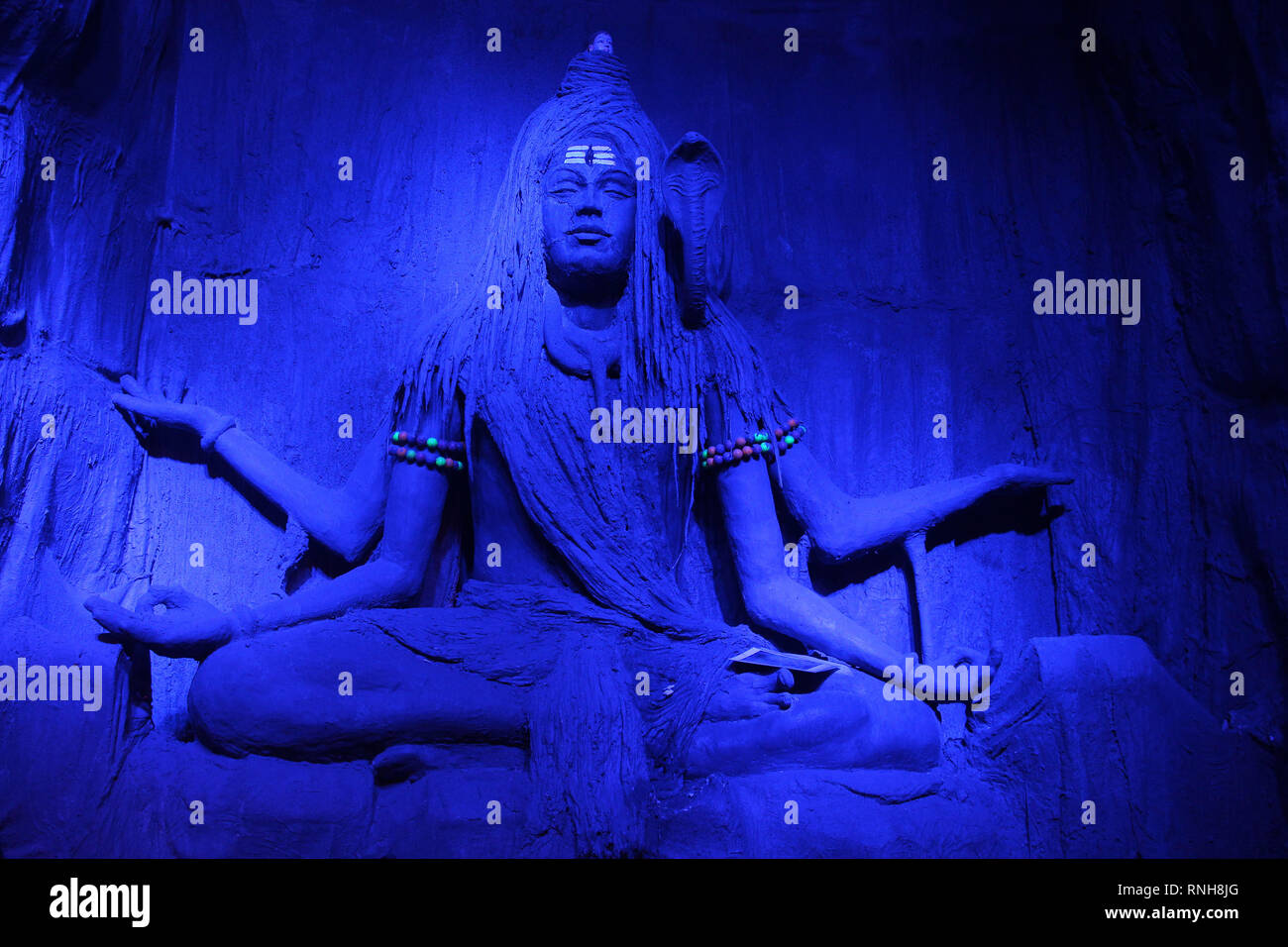 Faszinierende Skulptur von Lord Shiva meditierend in einem blauen Licht während Ganpati Festival, Pune Stockfoto