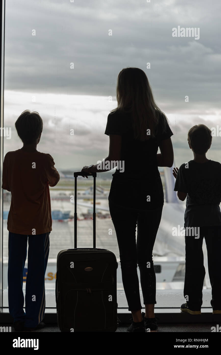 Silhouetten der Mutter mit Kindern im Terminal warten auf Flug Travel Concept Stockfoto