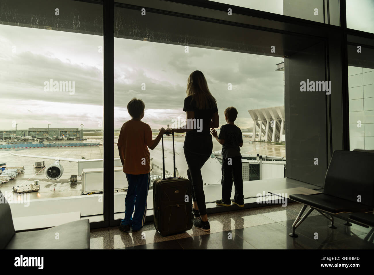 Silhouetten der Mutter mit Kindern im Terminal warten auf Flug Travel Concept Stockfoto