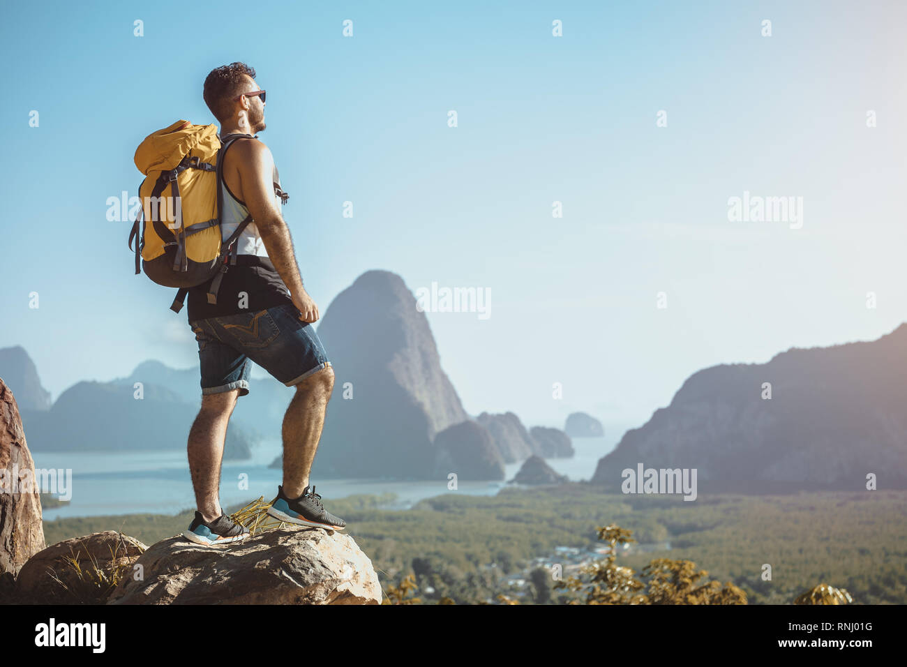 Wanderer steht auf einem Berg oder Viewpoint und betrachtet mit Blick auf Meer und Inseln. Travel Concept Stockfoto