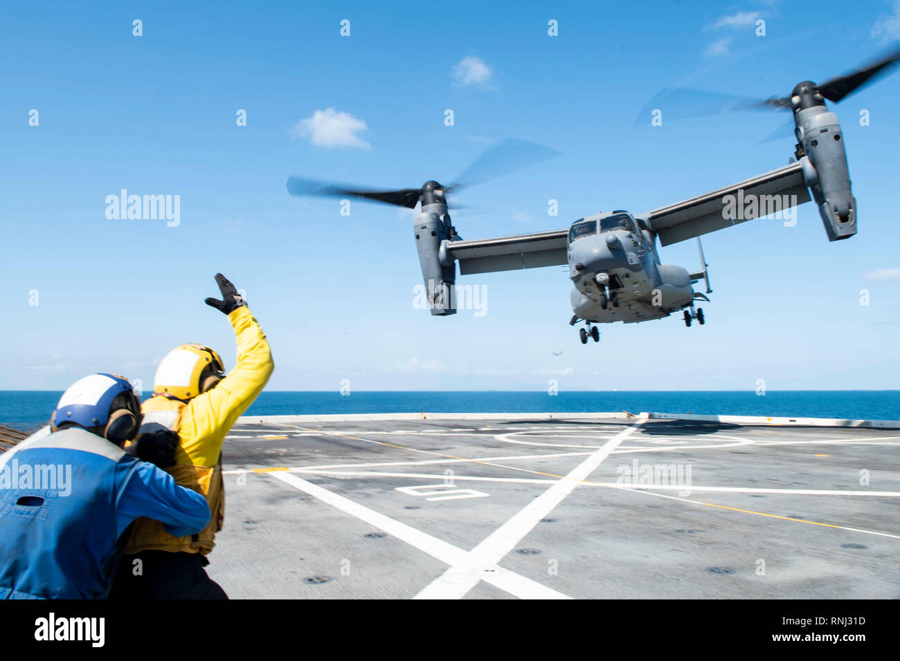 190218-N-DX 072-1683 GOLF VON THAILAND (Feb. 18, 2019) - Aviation Boatwain Mate's (Handling) 3. Klasse Walter Rutherford, von Cheyenne, Wyo. Signale für einen CV-22 Osprey Hubschrauber, der 353 Special Operations Gruppe zugeordnet, wie es braucht, um von der Flight Deck des amphibious Transport dock Schiff USS Green Bay LPD (20). Green Bay, Teil der Wasp amphibischen bereit, Gruppe, mit Eingeschifft 31 Marine Expeditionary Unit (MEU), in Thailand, die in der Übung Cobra Gold 2019 zu beteiligen. Cobra Gold ist eine multinationale Übung von Thailand und den Vereinigten Staaten gesponsert, mit Vorteil Stockfoto