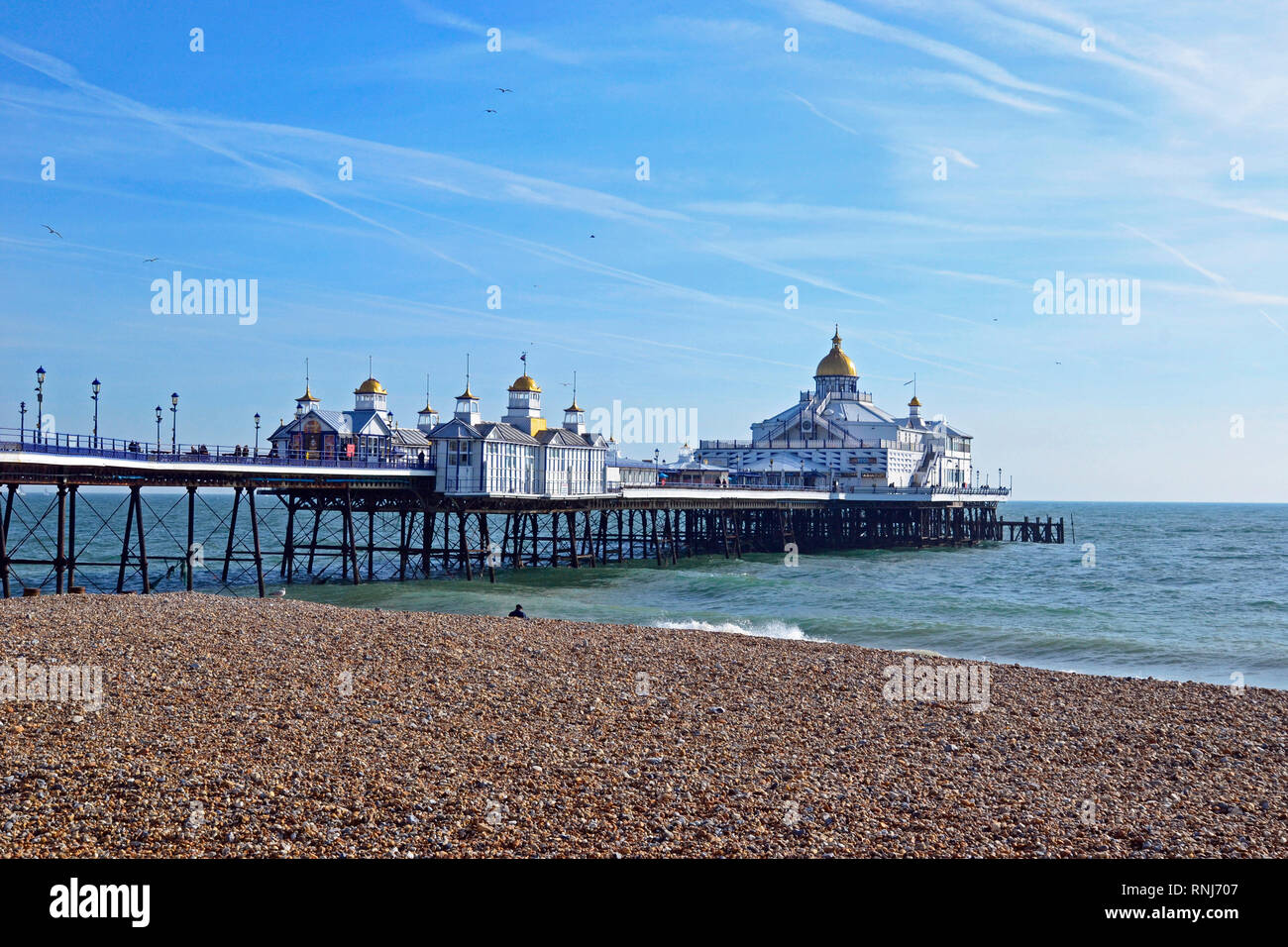 Eastbourne Pier, Eastbourne, East Sussex, UK. Strahlender Sonnenschein bringt Menschen aus dem Meer im Februar zu genießen. Blick von der Promenade aus. Stockfoto