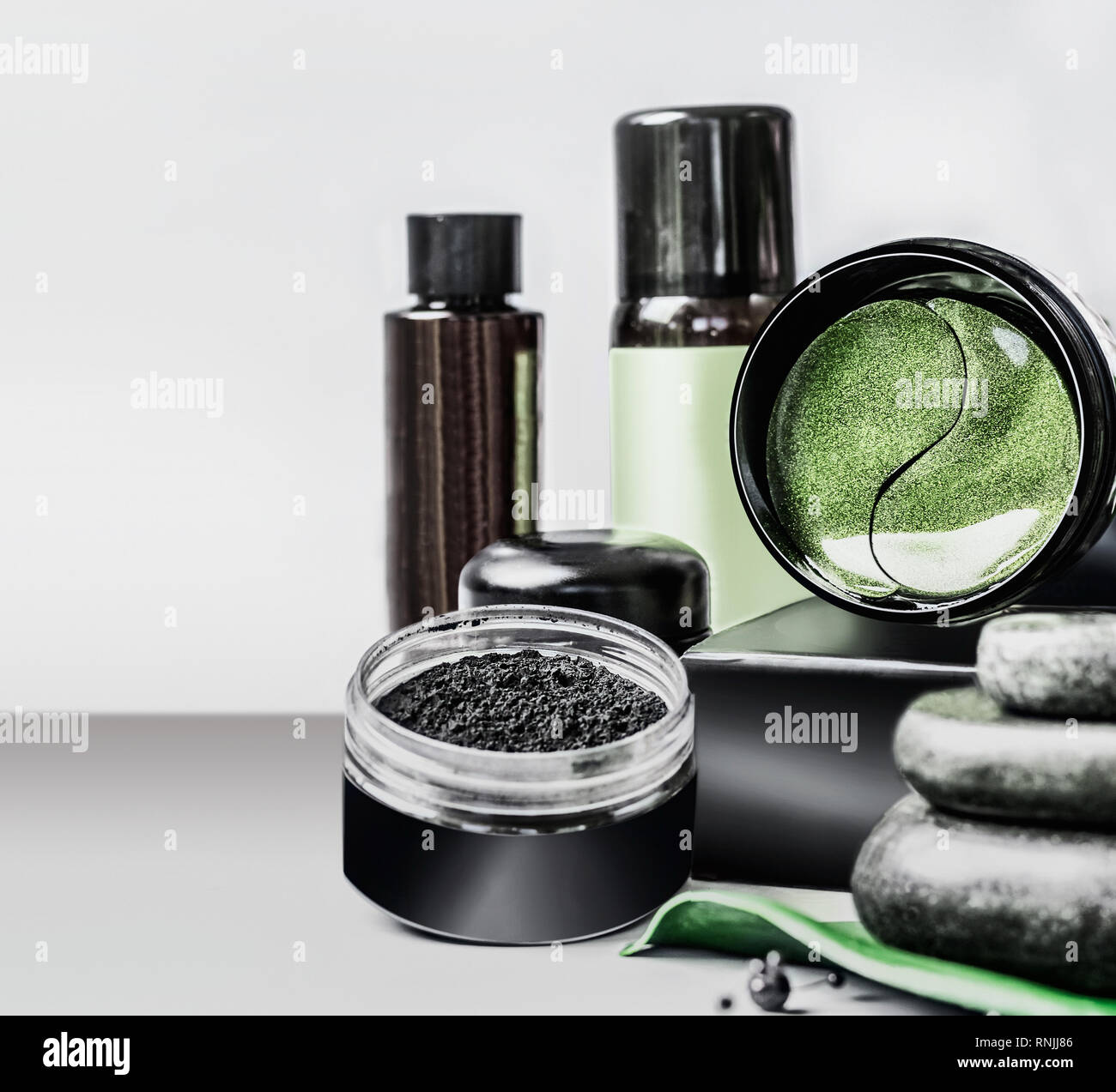 Kosmetik Einstellung anzeigen. Schwarz Package Template mit Holzkohle Pulver und green eye Patches. Branding mock up. Holzkohle kosmetische eingestellt. Gesichtspflege. Stockfoto