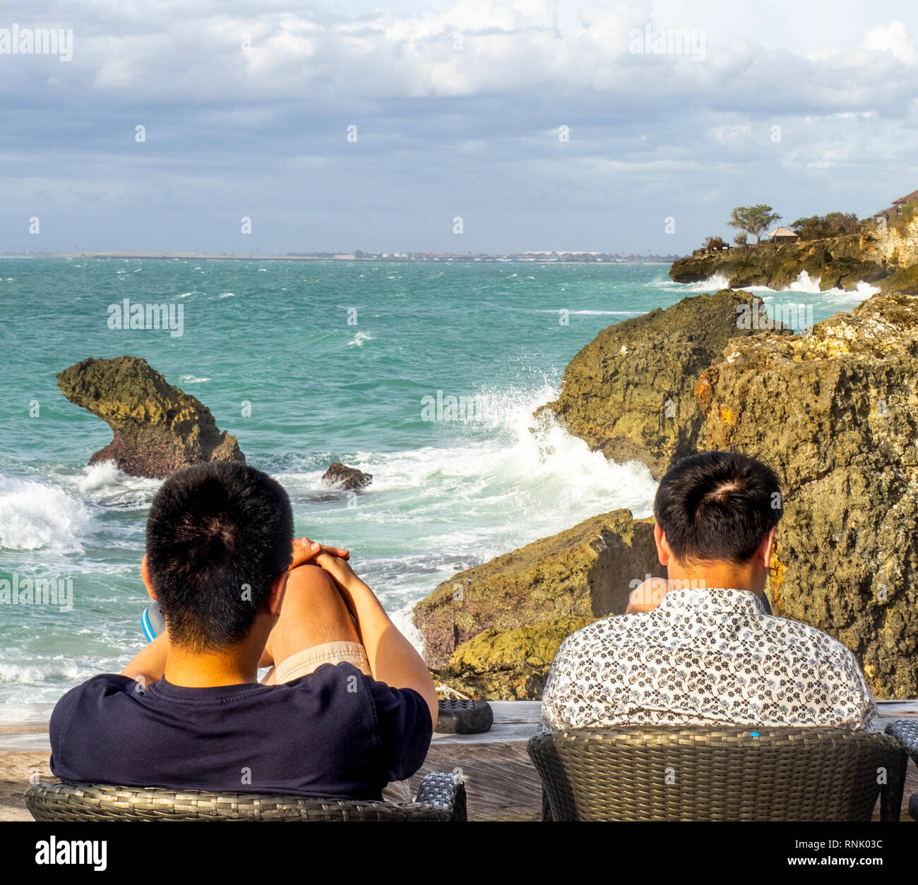 Zwei Chines männliche Touristen in der Rock Bar am Ayana Resort & Spa Jimbaran Bali Indonesien. Stockfoto