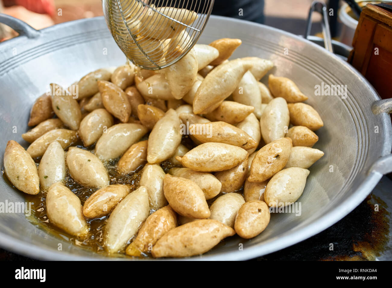 Flache Schüssel mit traditionellen asiatischen Street Food im heißen Öl auf dem Markt in Bangkok, Thailand. Closeup horizontale Foto. Stockfoto