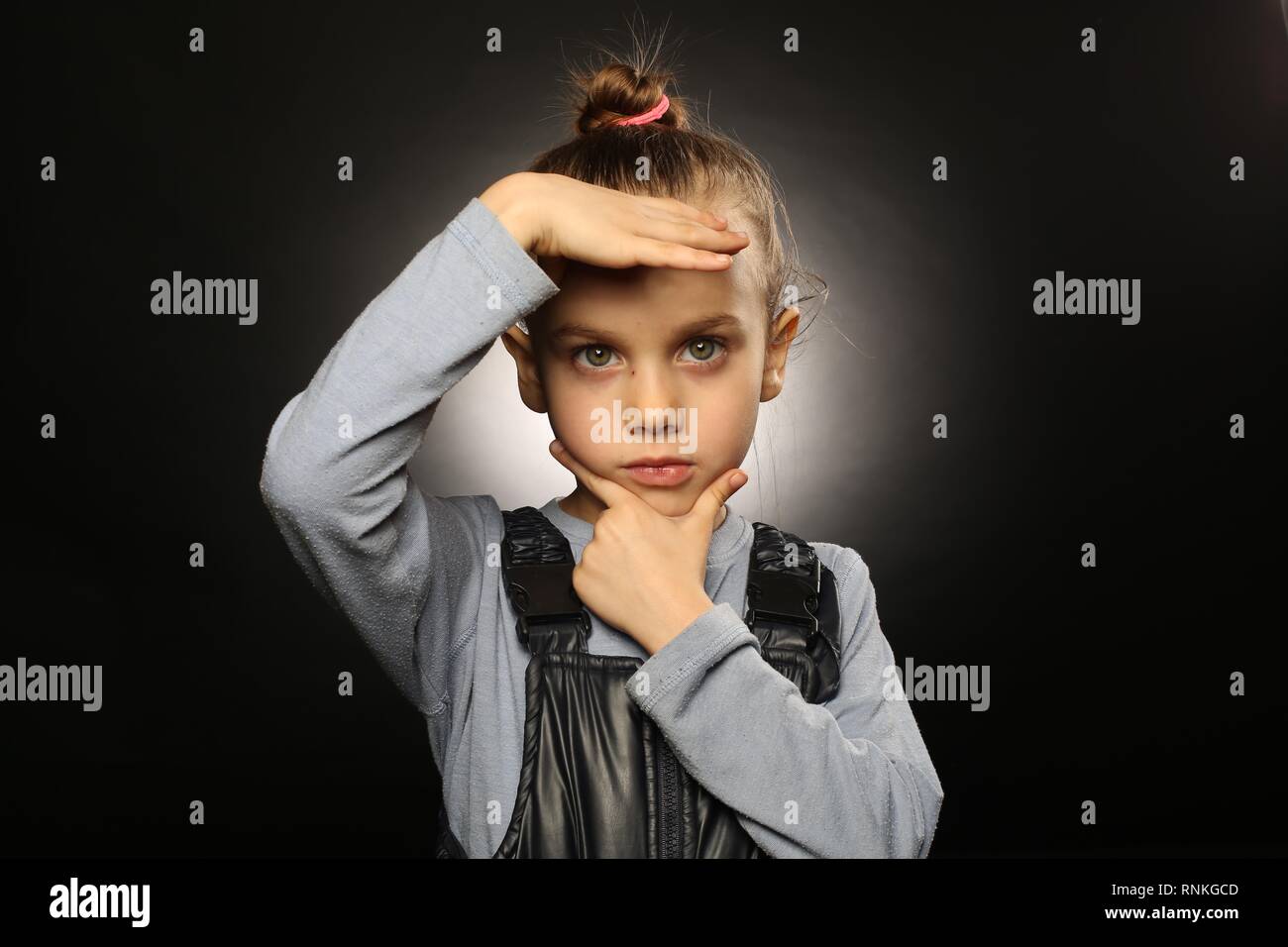 Ukrainische Mädchen, 5-9 Jahre alt, in Overalls, hält die Hände an einem ernsten, schönes Gesicht, mit einer geraden Blick in die Kamera Stockfoto