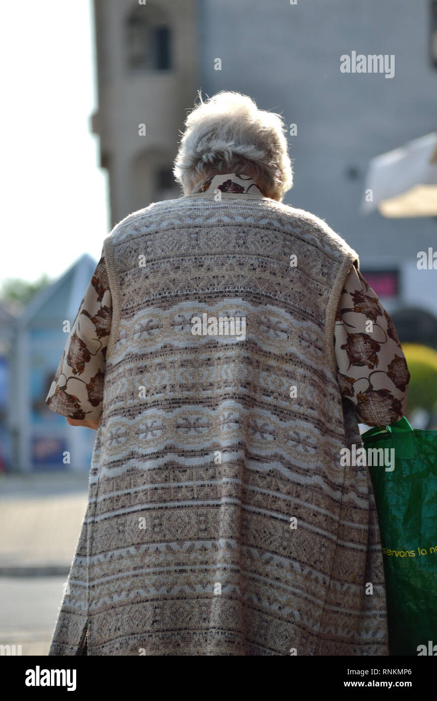 Ältere Frau allein auf Pflaster Stockfoto