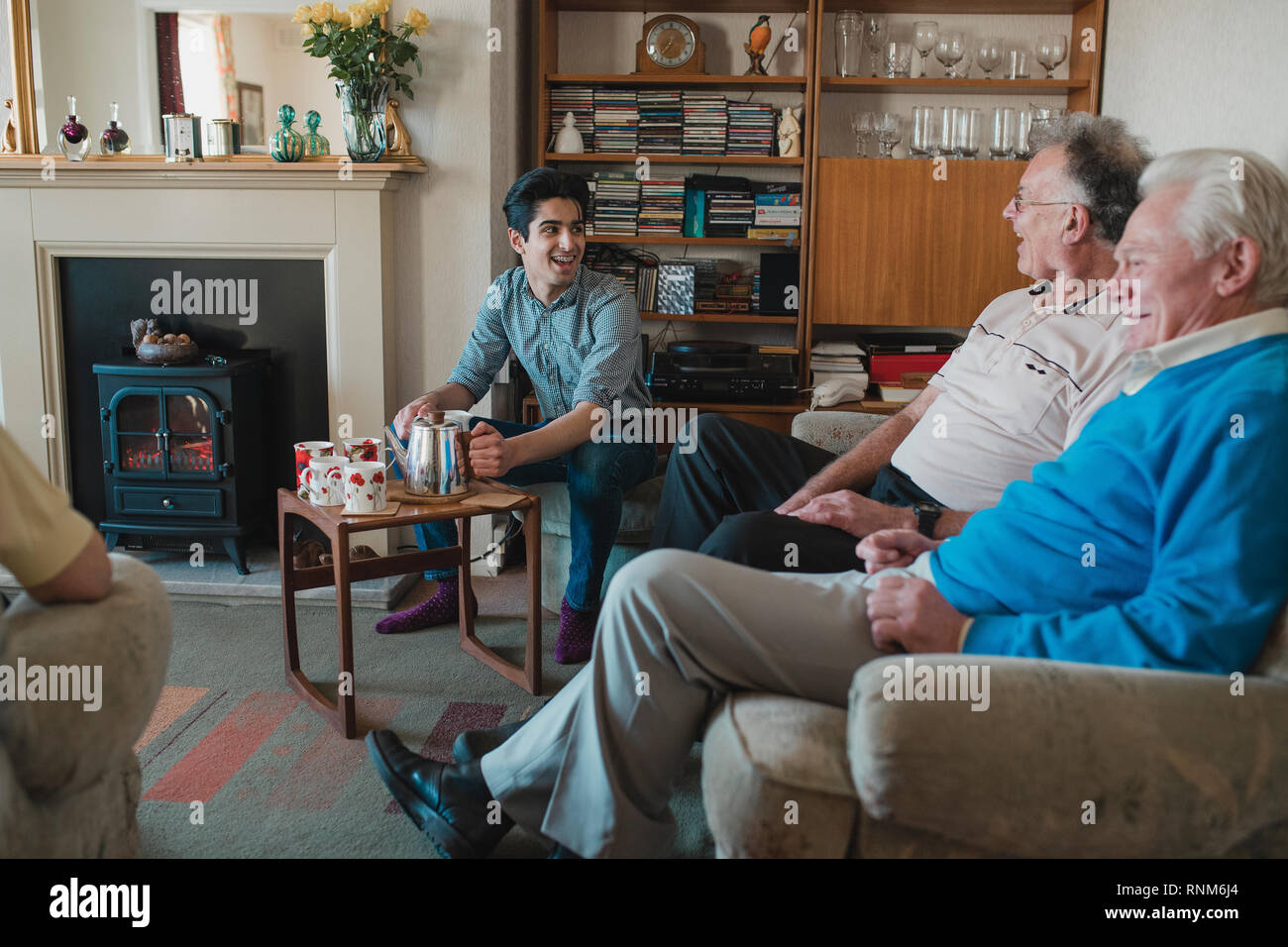 Teenager unterstützt ältere Erwachsene mit einem Tea Party in einem Pflegeheim. Stockfoto