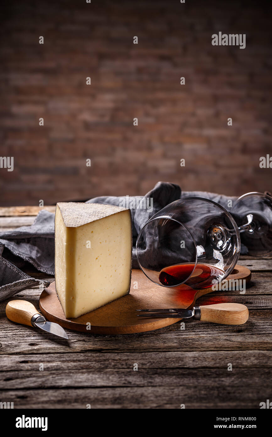 Keil der Käse mit einem Glas Rotwein auf dem Vintage Holz- Hintergrund Stockfoto