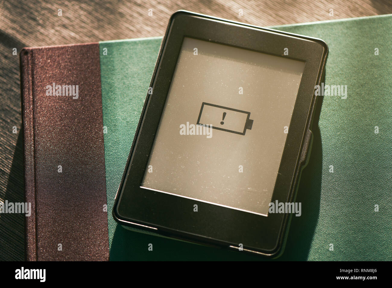 Symbol für schwache Batterien e-book e-Reader Bildschirm mit warmen Sonnenlicht Stockfoto