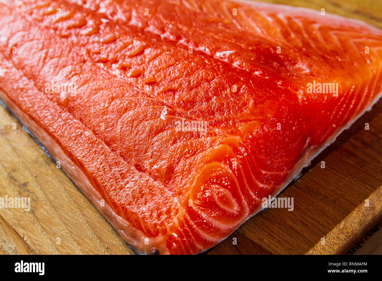 Große filet Schneiden von dunkelrot Atlantischen Lachs isoliert auf ein Holz Hintergrund Stockfoto