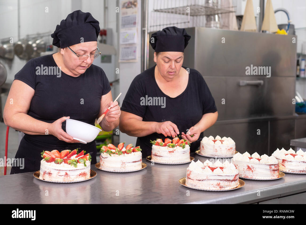 Zwei Frau Konditoren zusammen arbeiten, Kuchen in der Konditorei. Stockfoto