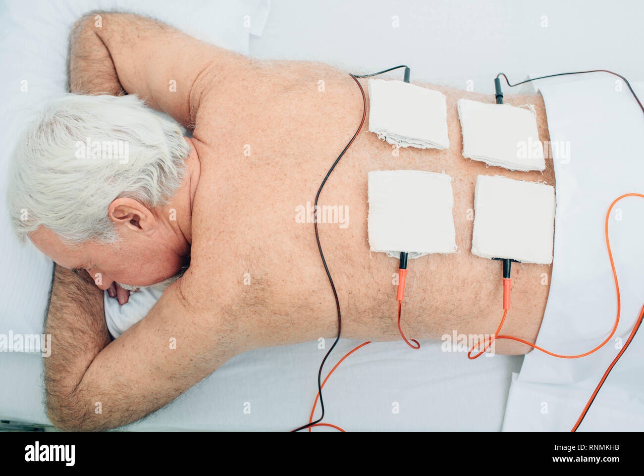 Die physiotherapeutische Behandlung. Ältere Patienten mit Ultraschall und Elektrotherapie Behandlung auf seinem Rücken Stockfoto