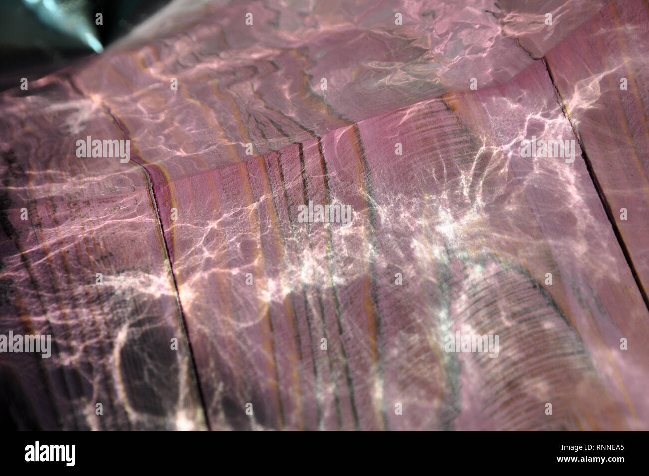Lichtreflexe von Folie auf der rosa Holztisch, abstrakten Hintergrund Stockfoto