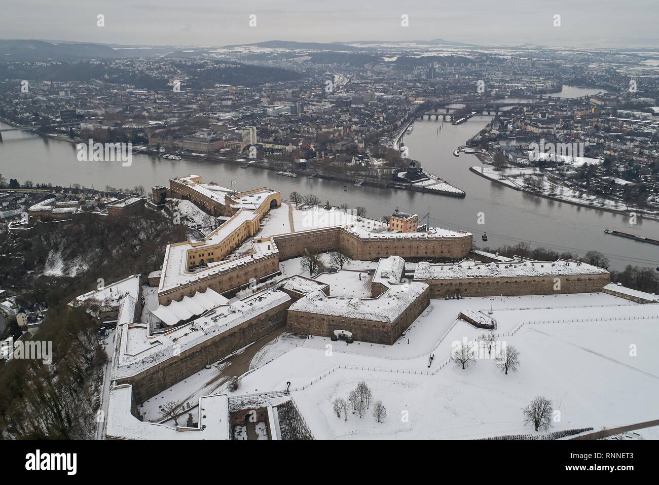 Die schneebedeckte Festung Ehrenbreitstein in Koblenz hoch über das Deutsche Eck am Zusammenfluss von Rhein und Mosel Stockfoto