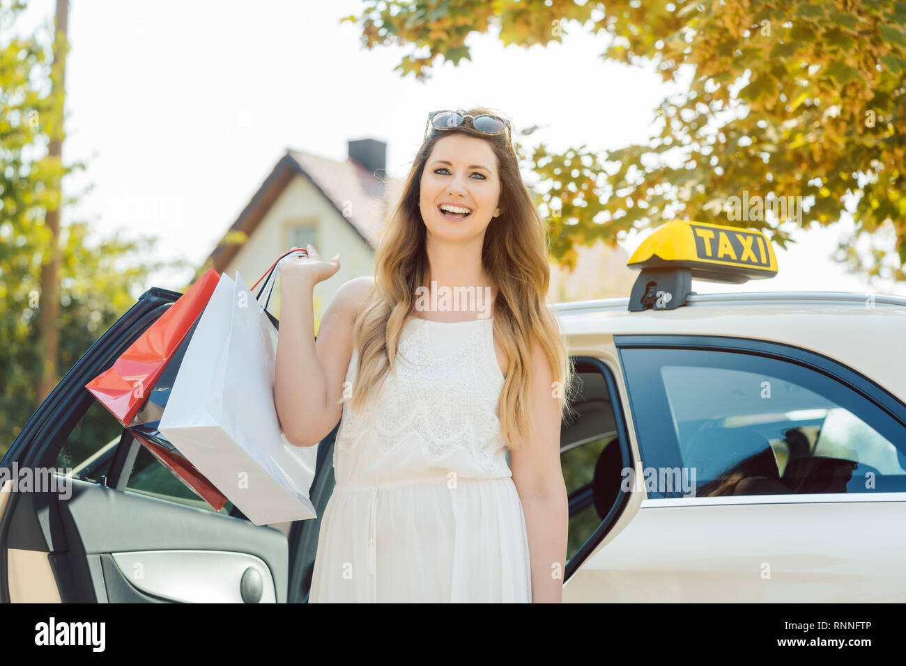 Frau aus dem Taxi Auto Durchführung Einkaufstüten Stockfoto