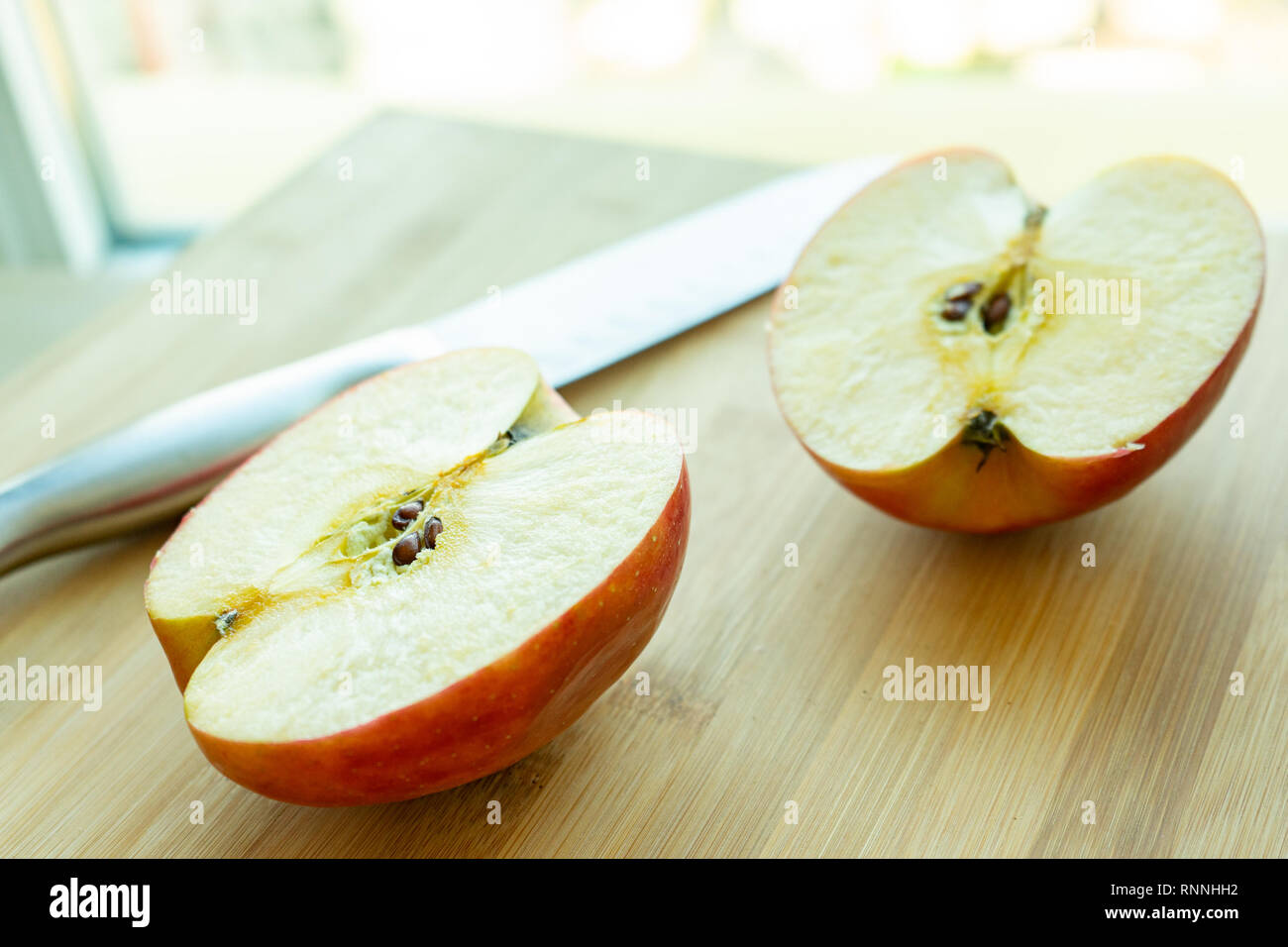 In Scheiben geschnitten Apfel auf Bambus Schneidebrett mit Messer Stockfoto