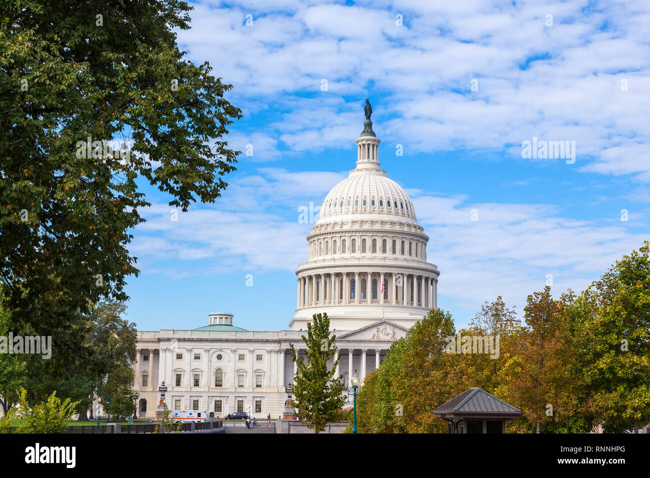 Washington DC, USA: Capitol USA Gebäude am Tag. gelb-grüne Bäume im Herbst. Weiße Feder Wolken und blauer Himmel. United States Con Stockfoto