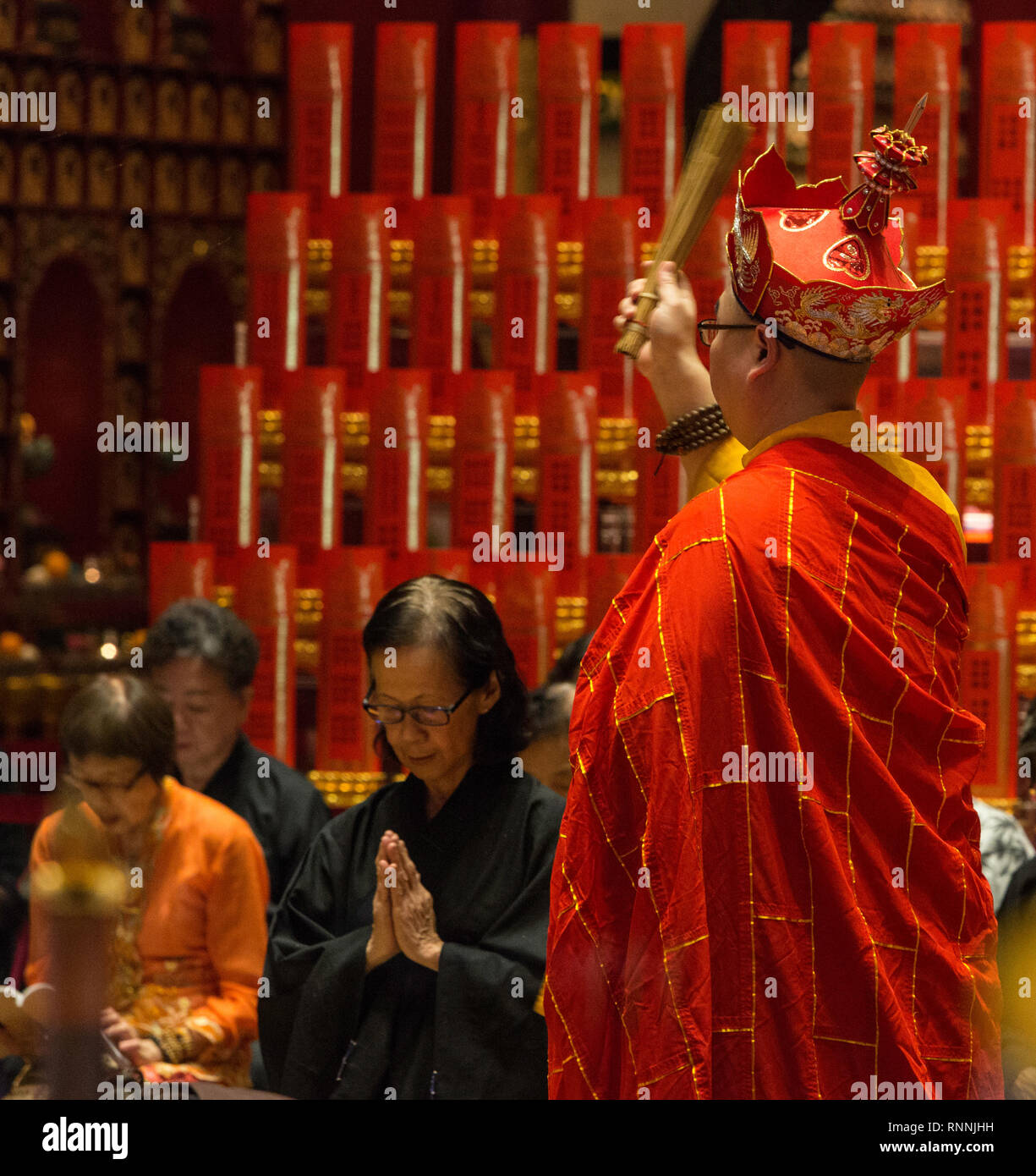 Buddhistischer Priester werfen Wassertropfen auf Beten Anbeter, Buddha Zahns Tempel, Singapur. Stockfoto