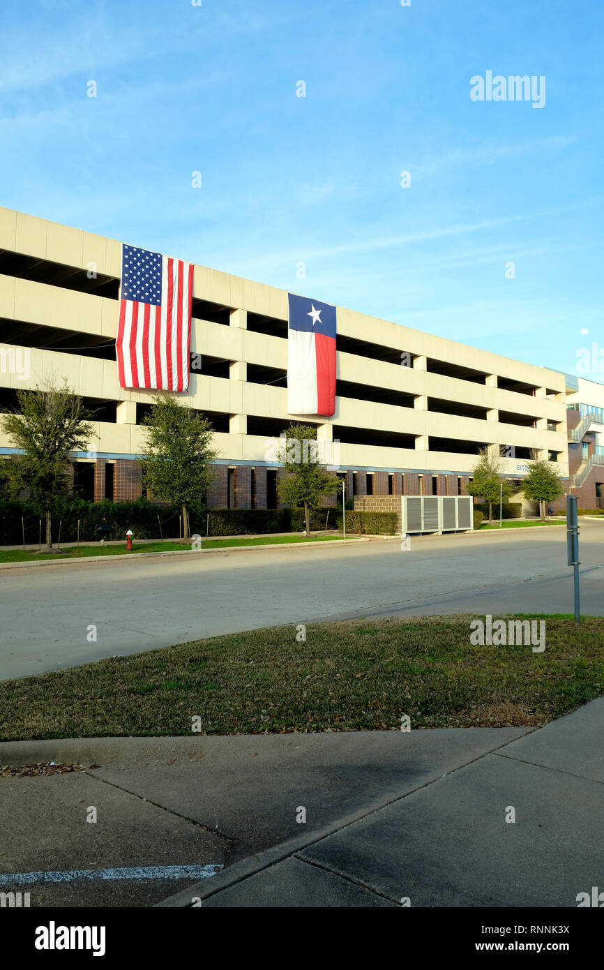 Amerikanische und Texas Fahnen drapiert über der Seite des Roy Kelly Garage Gebäude in der Innenstadt von Bryan, Texas, USA; Texas State Flag, amerikanische Flagge. Stockfoto