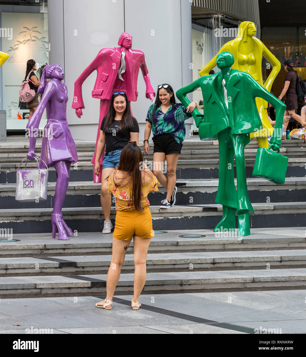 Käufer machen Fotos von modernen Skulpturen außerhalb ION Mall, von Singapur, der Orchard Road Street Scene. Städtische Bevölkerung von Kurt Lorenz Metzler. Stockfoto