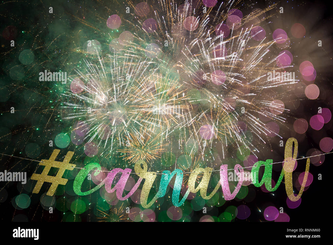 Karneval Nachricht (die portugiesische Schreibweise) in eleganten farbigen gold Script mit einer modernen sozialen Medien hashtag aufgereiht vor Feuerwerk Stockfoto