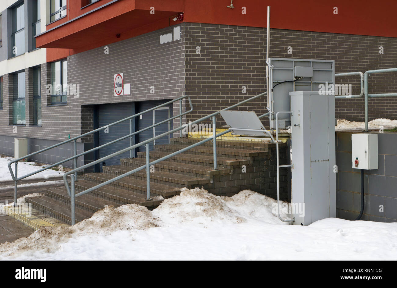 Elektrische Aufzug für behinderte Menschen in der Nähe der Treppen eines Wohnhauses installiert. Die Massenproduktion. Panorama winter geschossen Stockfoto