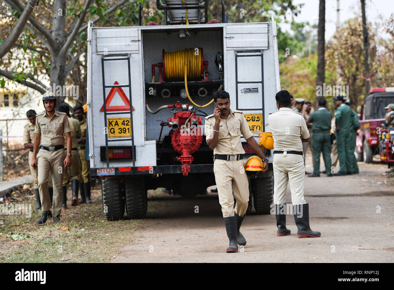 Bangalore, Karnataka, Indien. 19 Feb, 2019. Die Feuerwehr Team vor Ort gesehen zu begießen, das Feuer und die Trümmer der 2 Surya Kiran's, die in Bengaluru während einer Praxis, die Sitzung vor dem Aero-zeigen, dass morgen, wo 2 Piloten verletzt wurden und 1 bestätigten Toten beginnen abgestürzt ist klar. Credit: Meghana Sastry/SOPA Images/ZUMA Draht/Alamy leben Nachrichten Stockfoto