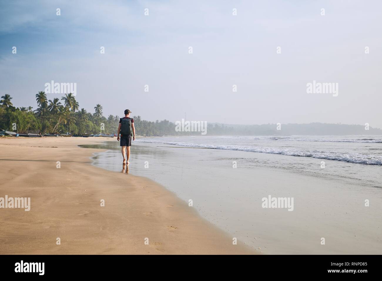 Jungen Touristen zu Fuß am Sandstrand mit Palmen. Küste in der Nähe von Tangalle in Sri Lanka. Stockfoto