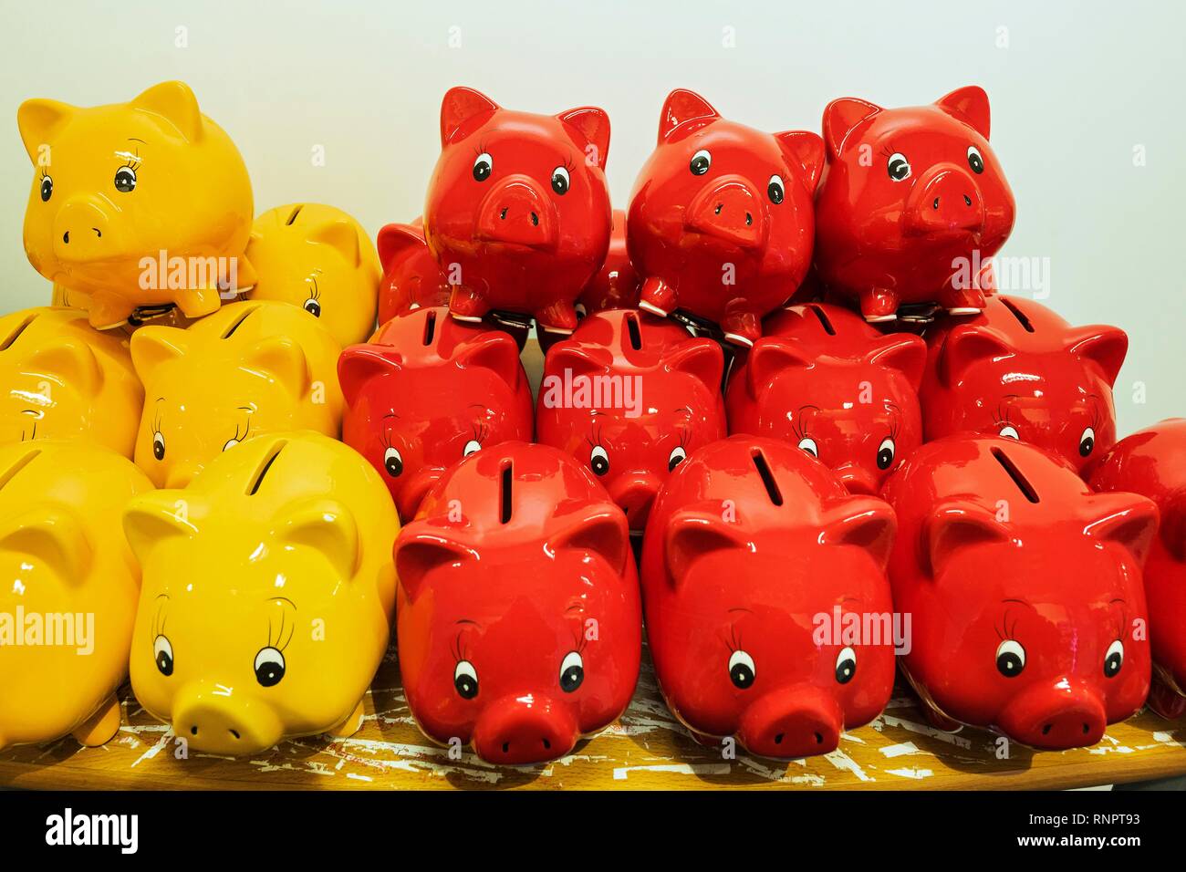 Rote und gelbe Sparschweine in einem Kaufhaus, München, Oberbayern, Bayern, Deutschland Stockfoto