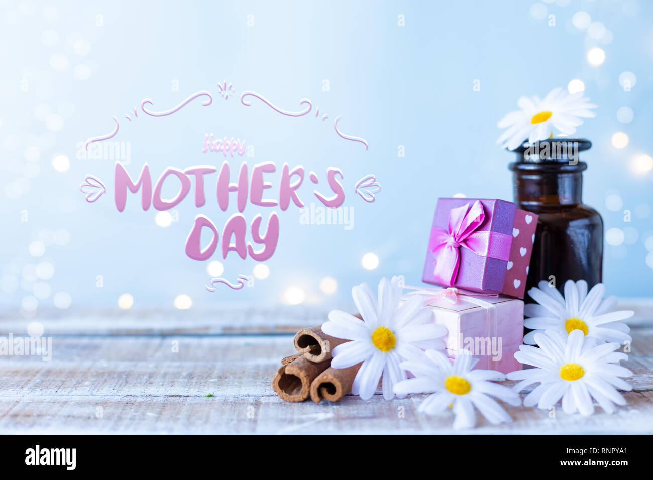 Kartons mit Geschenken, einen Blumenstrauß, Kosmetik Öl auf einem hellblauen Hintergrund mit der Aufschrift Happy Muttertag Schriftzug Stockfoto