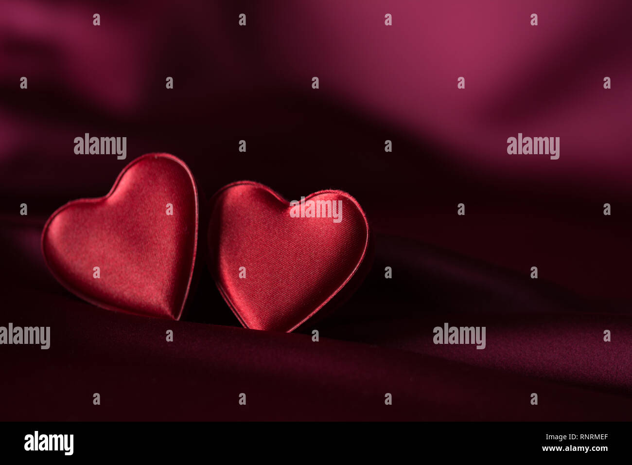 Zwei rote Herzen auf lila satin Stockfoto