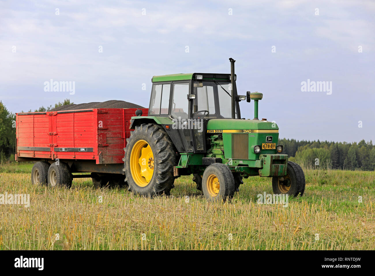 Salo, Finnland - 8 September, 2018: John Deere 3140 farm Traktor und landwirtschaftliche Anhänger voller geerntete Raps an einem schönen Tag im Herbst. Stockfoto