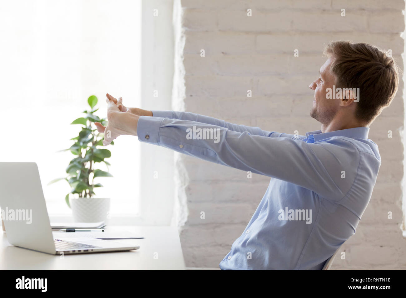 Arbeitnehmer tun effektive Dehnübungen während des Arbeitstages Stockfoto