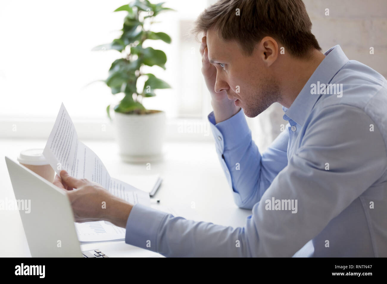 Mann lesen Benachrichtigung von der Bank über unbezahlte Schulden Stockfoto
