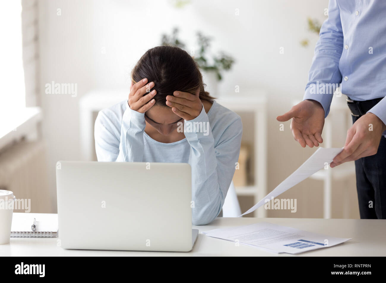 Boss wirft Büroangestellter Fehler im Bericht angezeigt. Stockfoto