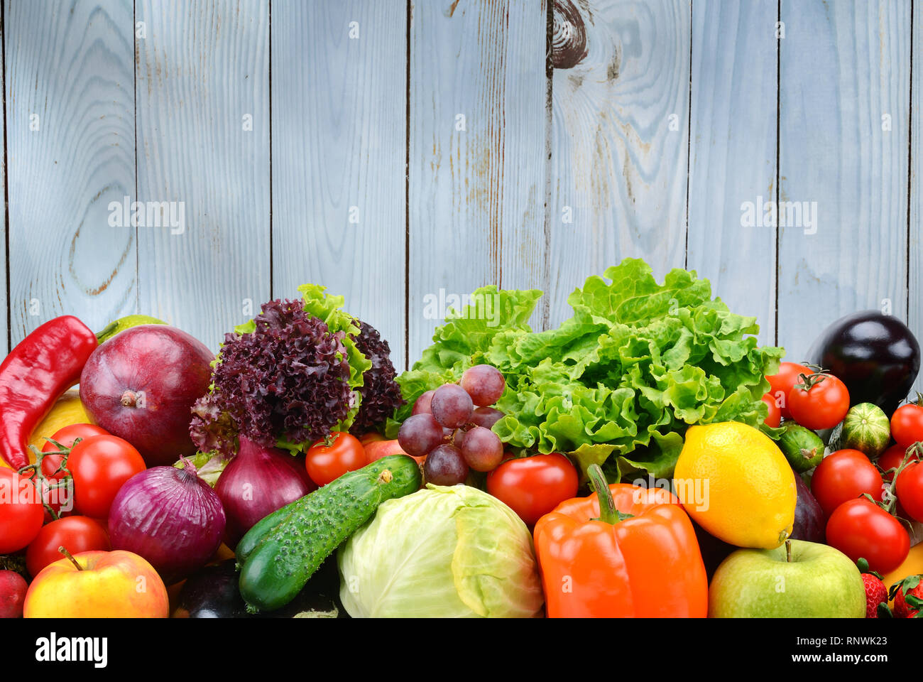 Nützliche Gemüse und Früchte auf hellblau Holz Wand Hintergrund. Gesunde Lebensmittel. Stockfoto