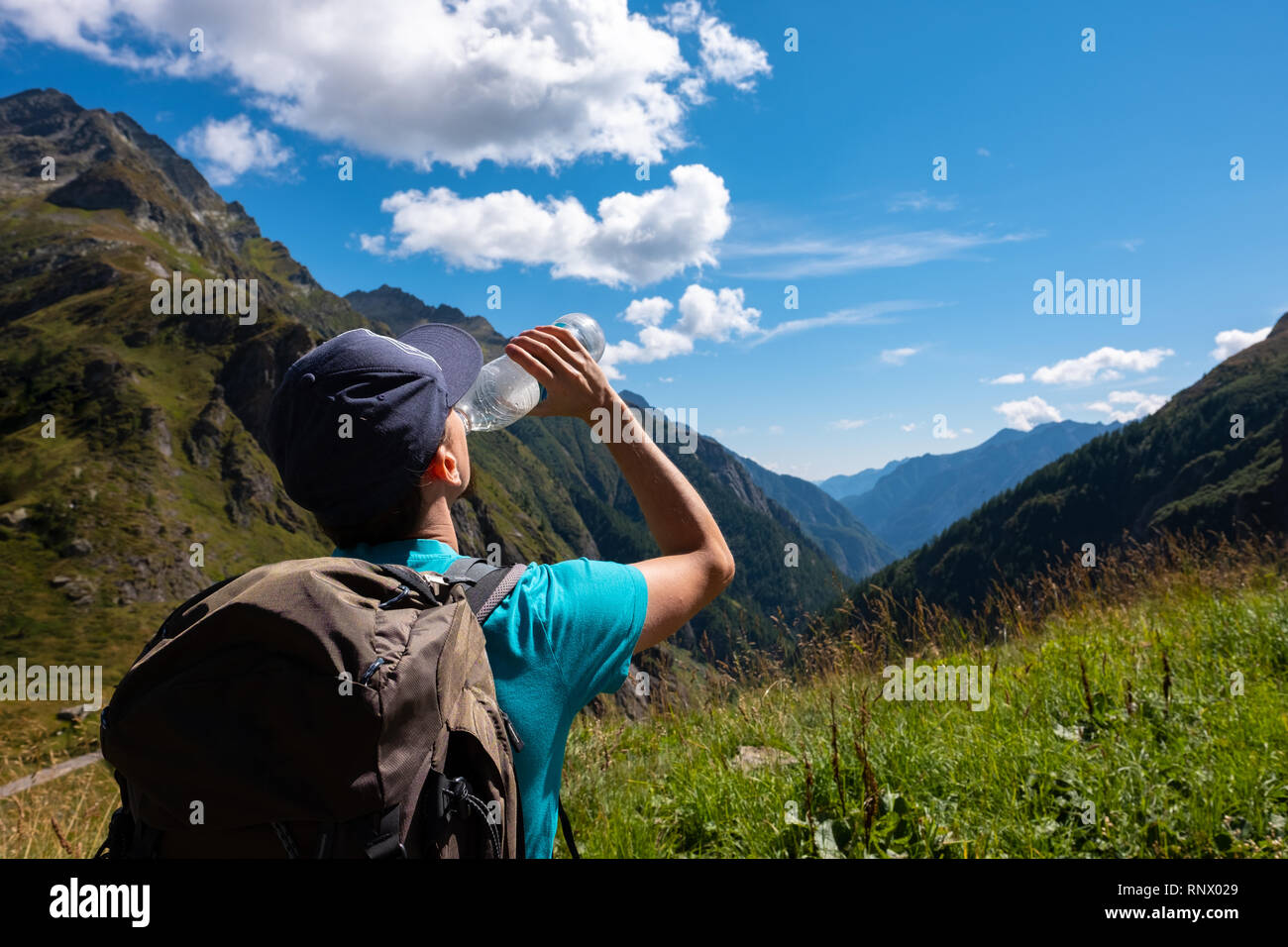 Junge Mann ist das trinken eine Flasche Wasser bei einer Wanderung in den Bergen Stockfoto