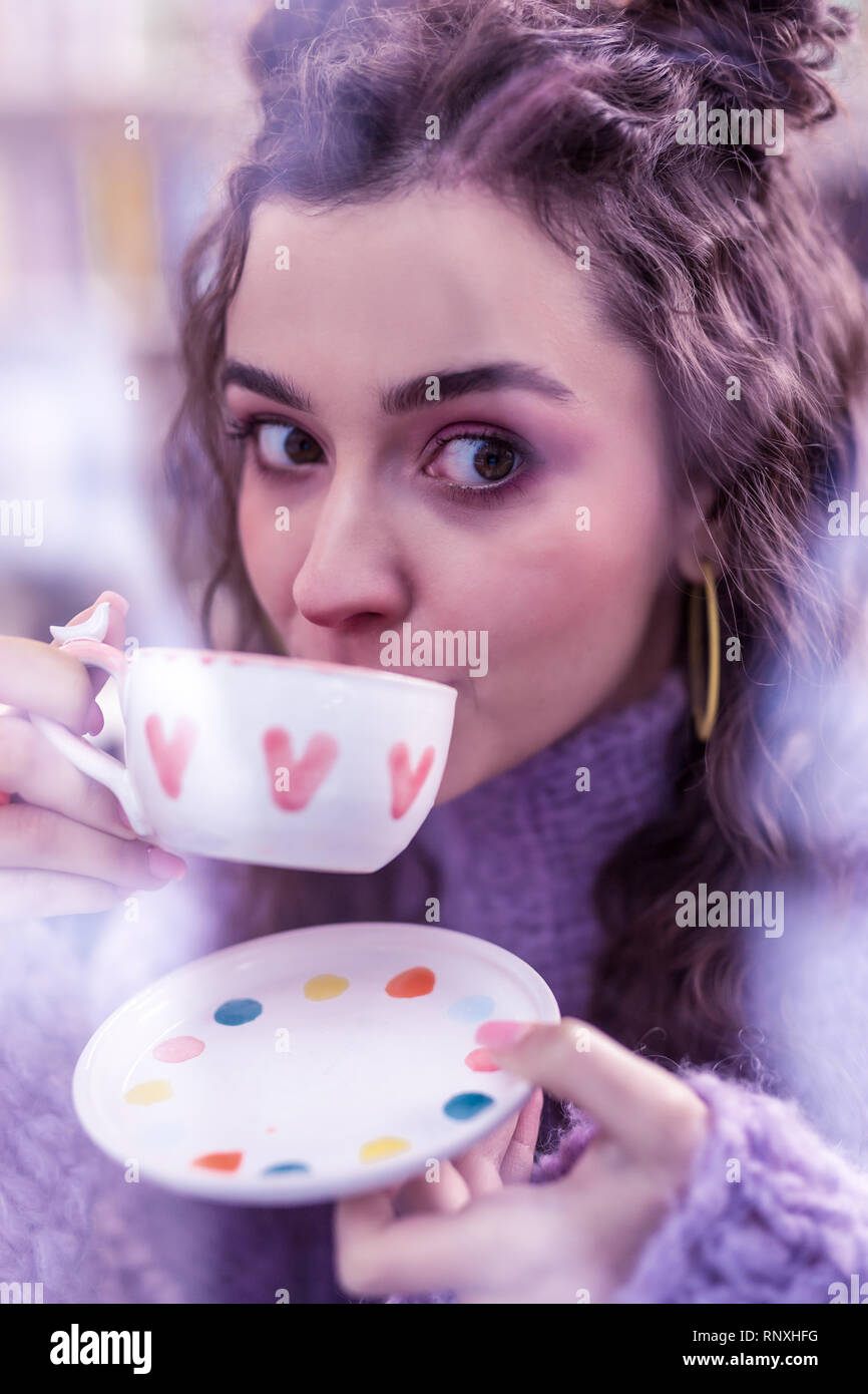 Attraktive dunkelhaarige Frau mit grossen braunen Augen Tasse Tee Stockfoto