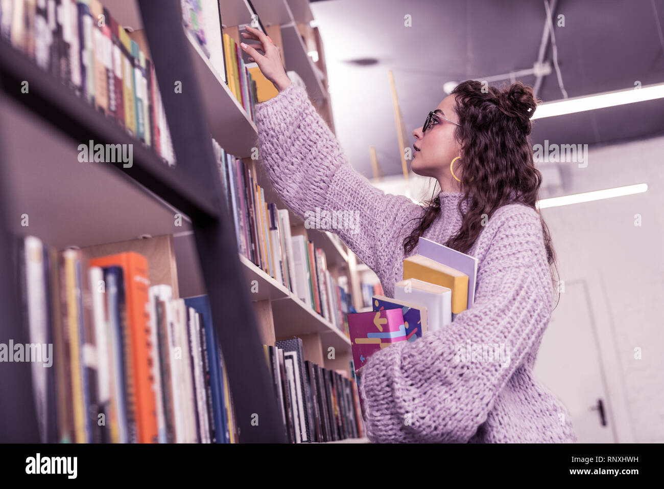 Resolute gut aussehende Mädchen in der Runde Gläser Buch erhalten Stockfoto