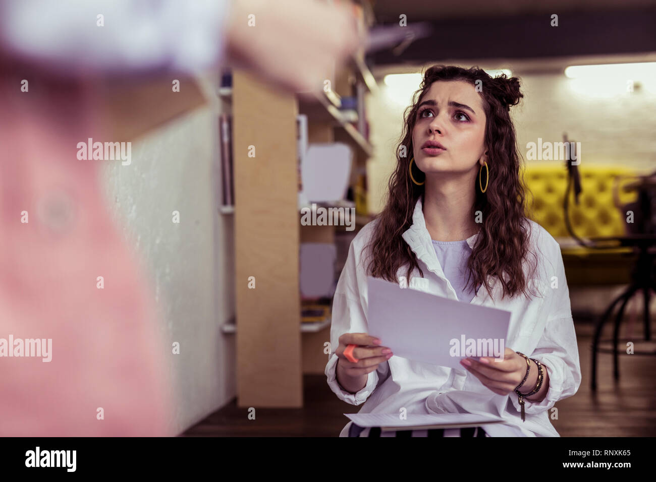 Erschrocken, langhaarige Mädchen mit gelben Ohrringe hoffentlich Stockfoto