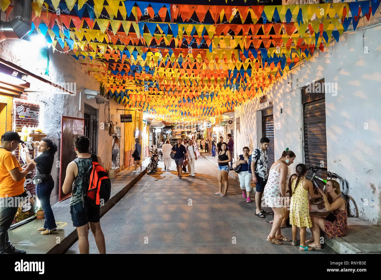 Cartagena Kolumbien, Zentrum, Zentrum, Getsemani, Abenddämmerung in der Nacht, Einwohner der hispanischen Nachbarschaft, Calle San Andres, bunte Fahnen, Männer Stockfoto