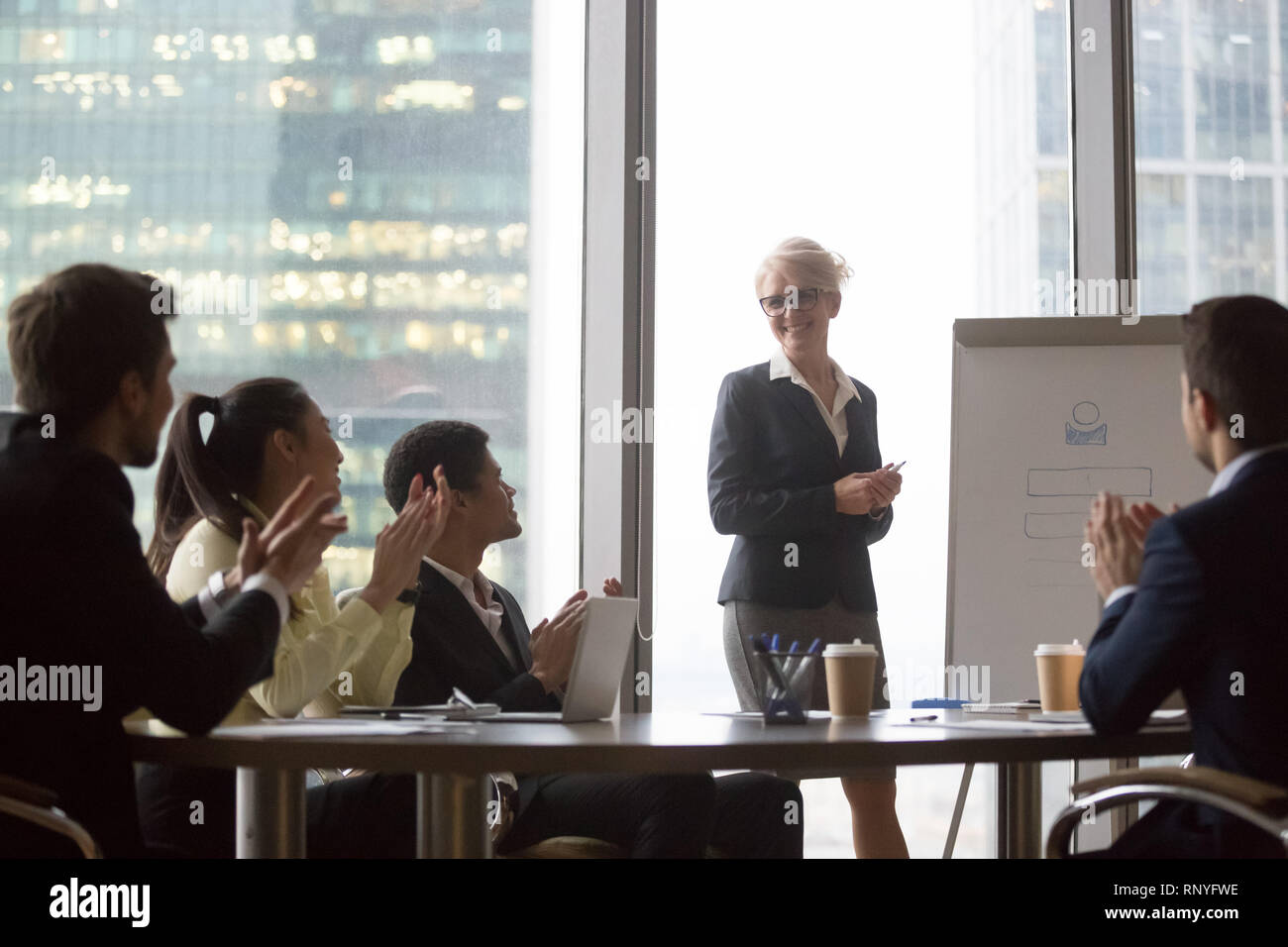 Diverse Geschäftsleute dankbar applaudieren zu Lautsprecher mit Präsentation gratulieren. Stockfoto