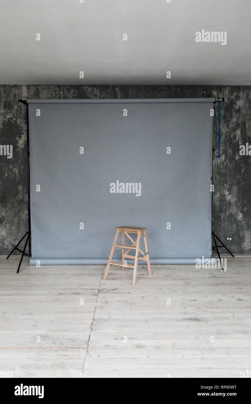 Der Arbeitsbereich des Photo Studio mit grauem Papier Hintergrund und Stuhl. Stockfoto