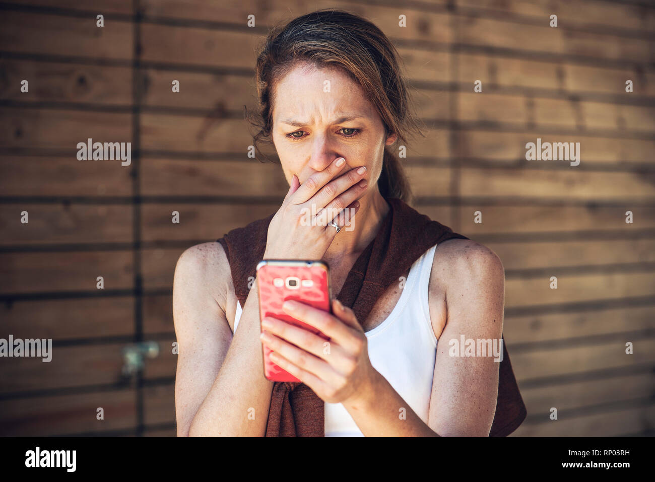 Ernsthafte reife Frau bei smart phone suchen Stockfoto