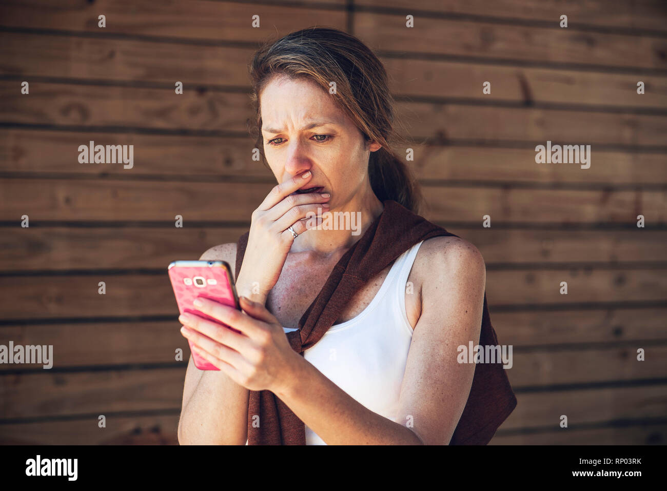 Ernsthafte reife Frau bei smart phone suchen Stockfoto