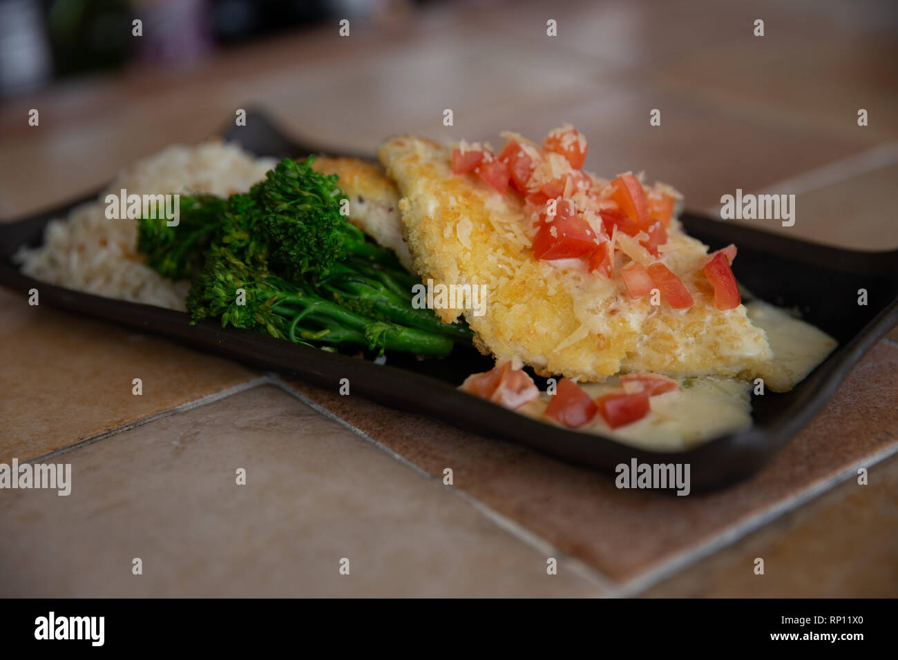 Panko verkrusteten Huhn mit Bluere Blanc Sauce zusammen mit Brocollini und Basmatireis Stockfoto